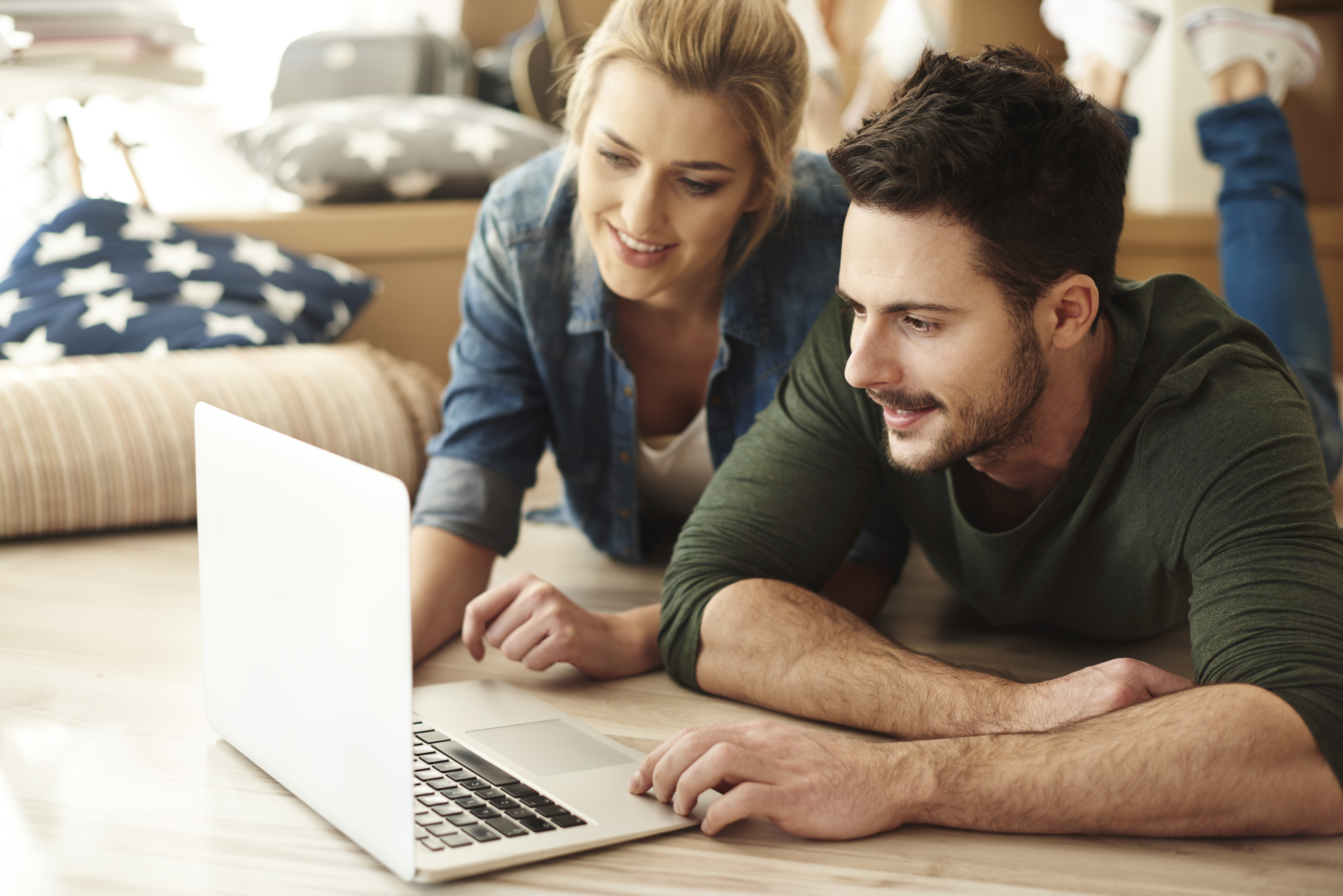 Young couple in flat using laptop